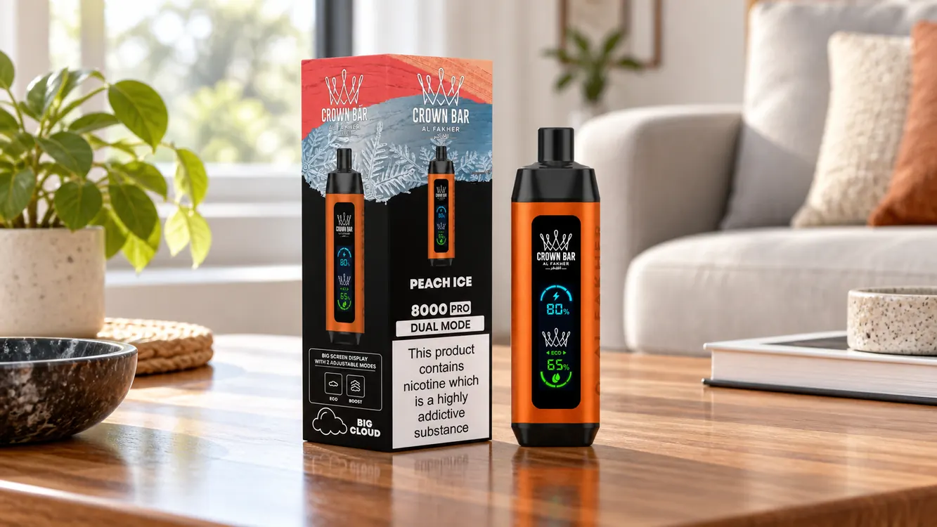 Al Fakher Crown Bar 8K Pro saveur Peach Ice et sa boîte posées sur une table en intérieur, écran LED allumé